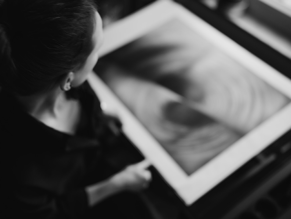 Die Künstlerin am Zeichentisch in Betrachtung ihrer Zeichnung mit dem Titel "Liebe".